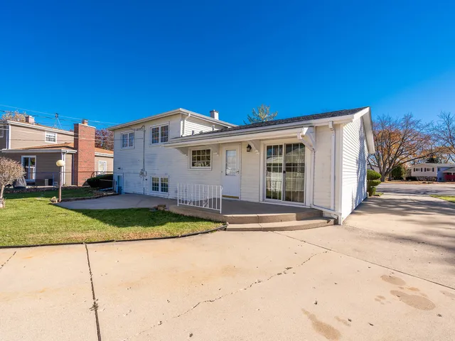 a view of a house with backyard and trees