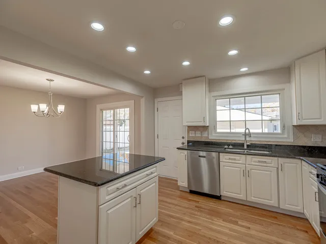 a kitchen with granite countertop a sink and cabinets