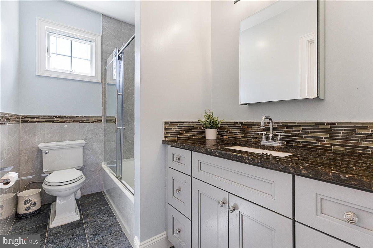 535 Village Road West Princeton Junction, NJ 08550 - Photo 32 of 51 a bathroom with a granite countertop sink a toilet and a mirror
