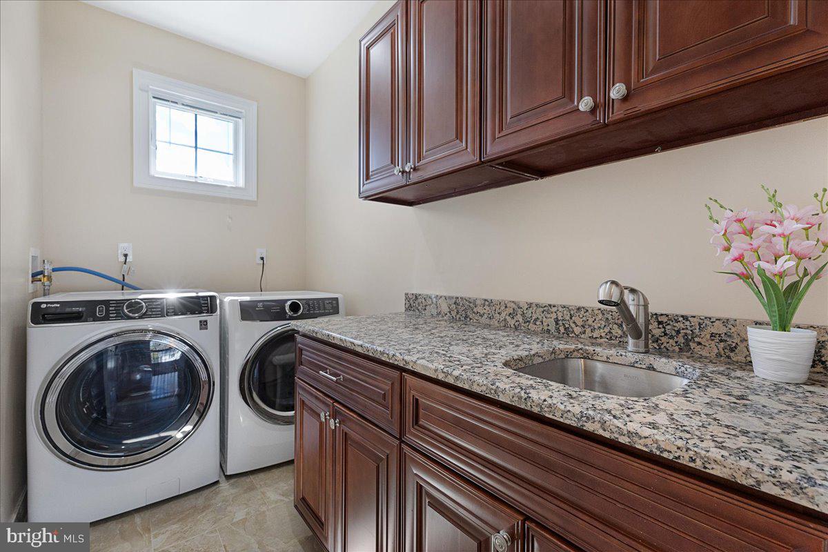 535 Village Road West Princeton Junction, NJ 08550 - Photo 33 of 51 a utility room with granite countertop a sink a washer and dryer