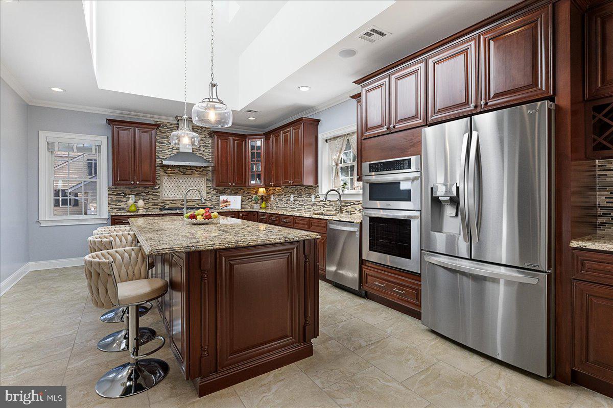 535 Village Road West Princeton Junction, NJ 08550 - Photo 10 of 51 a kitchen with granite countertop a refrigerator a stove a sink and a dining table