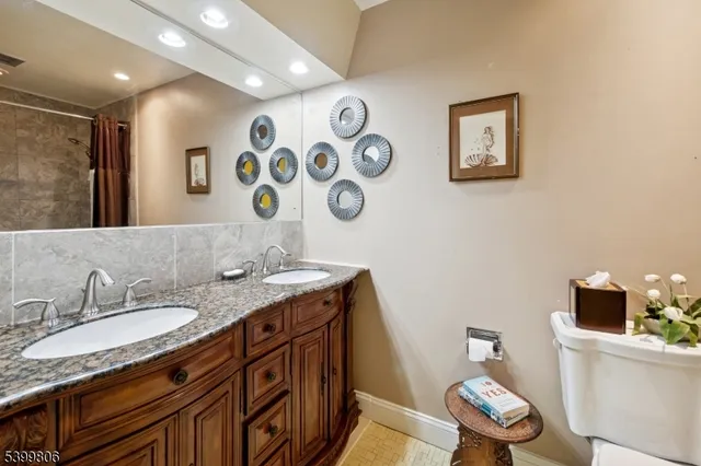 a bathroom with a granite countertop sink mirror vanity and toilet