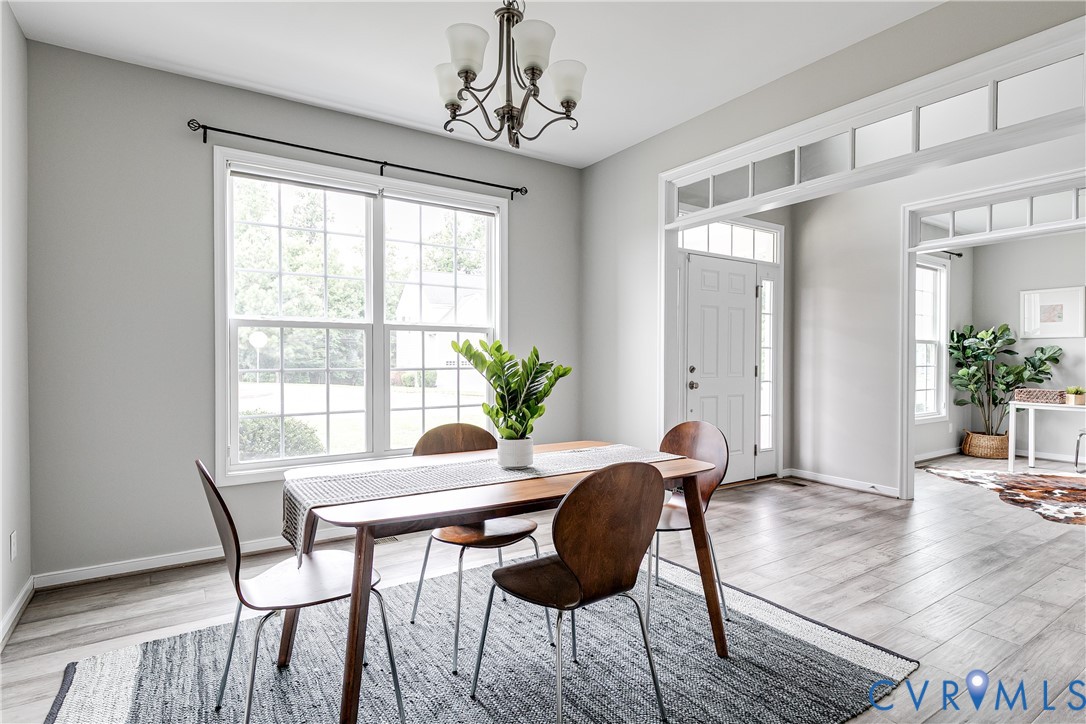 14906 Bridge Spring Drive Midlothian, VA 23113 - Photo 11 of 50 a dining room with furniture potted plants and wooden floor