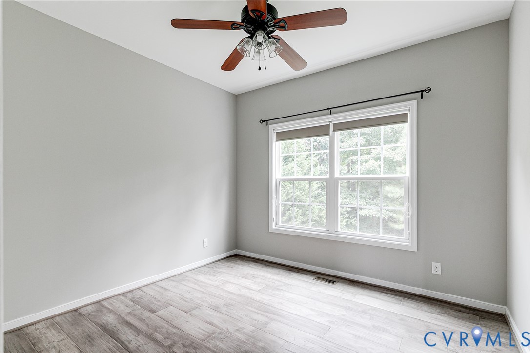 14906 Bridge Spring Drive Midlothian, VA 23113 - Photo 14 of 50 an empty room with chandelier fan and windows