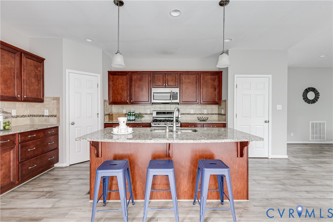 14906 Bridge Spring Drive Midlothian, VA 23113 - Photo 27 of 50 a kitchen with stainless steel appliances granite countertop a stove top oven a refrigerator a sink and white cabinets