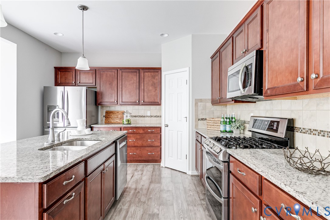 14906 Bridge Spring Drive Midlothian, VA 23113 - Photo 29 of 50 a kitchen with stainless steel appliances granite countertop a sink stove and refrigerator