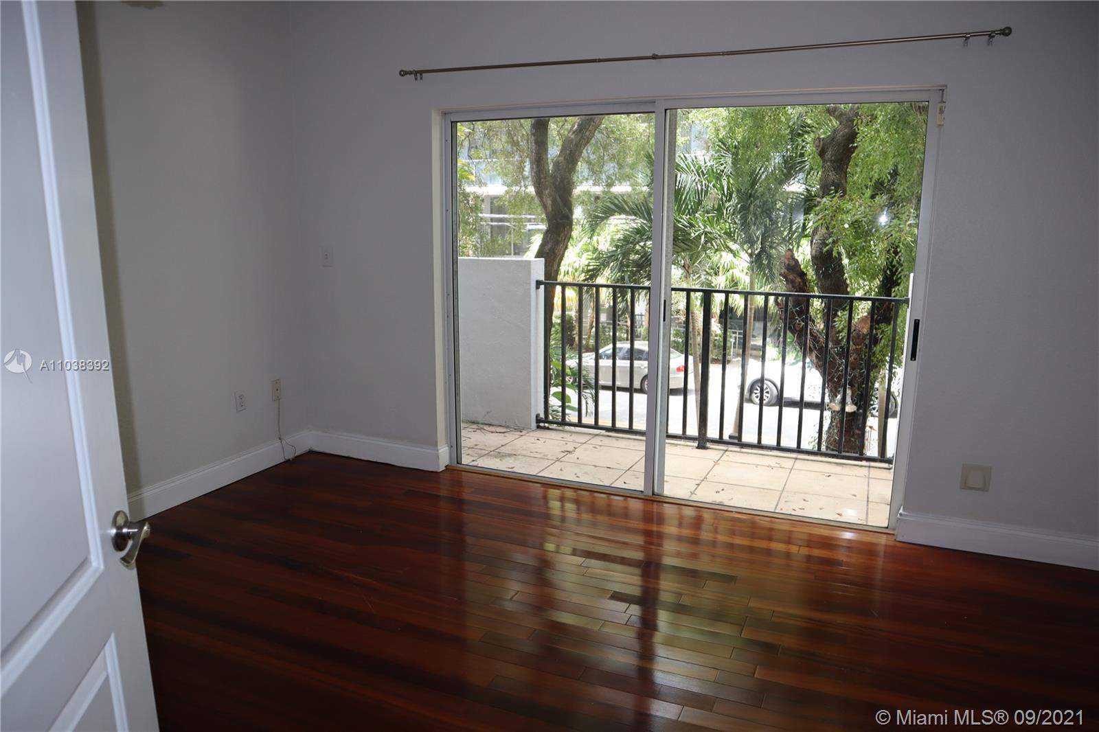123 Southwest 17th Road Miami, FL 33129 - Photo 19 of 28 a view of an empty room with wooden floor and a window