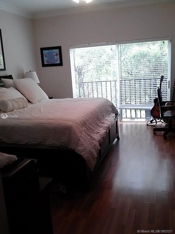 123 Southwest 17th Road Miami, FL 33129 - Photo 4 of 28 a bedroom with a bed a couch and a large window