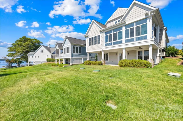 a view of a house with a big yard and large trees