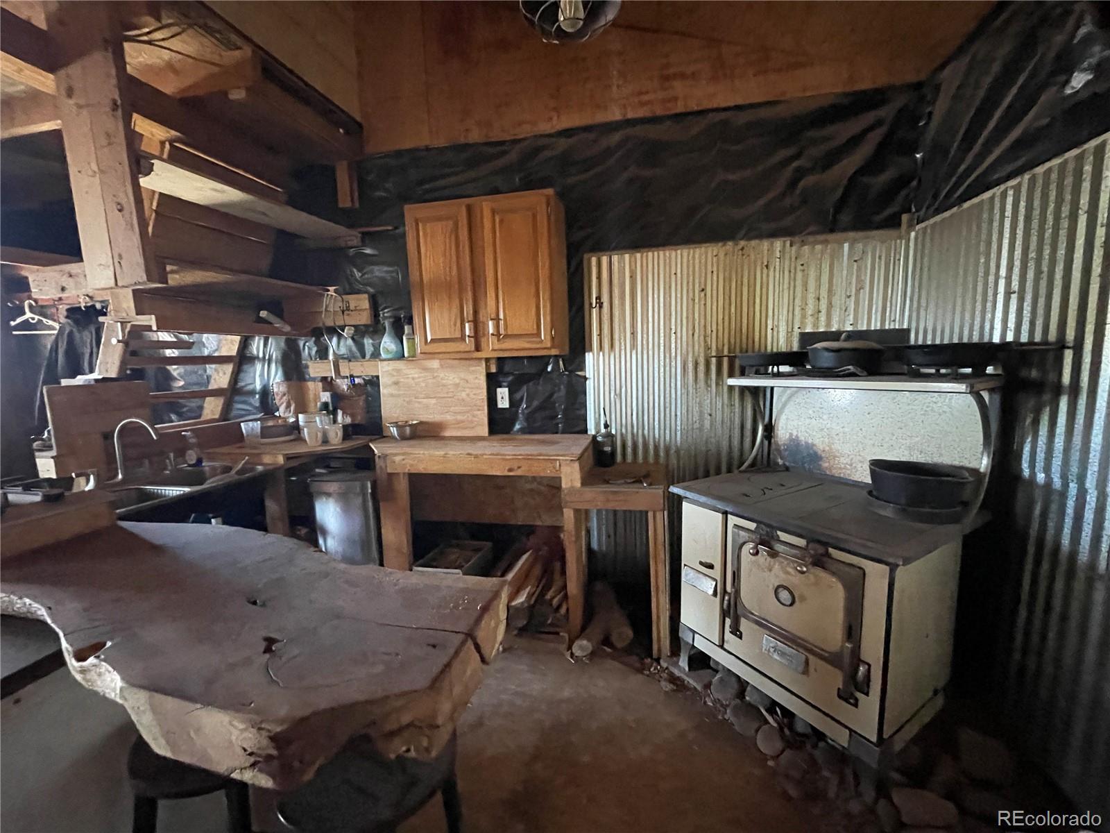 58313 County Road Villa Grove, CO 81155 - Photo 11 of 39 a kitchen with stainless steel appliances granite countertop a stove a sink dishwasher and cabinets with wooden floor