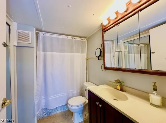 a bathroom with a sink toilet a mirror and shower