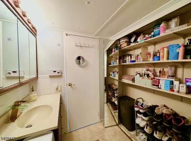 a bathroom with a refrigerator and a sink