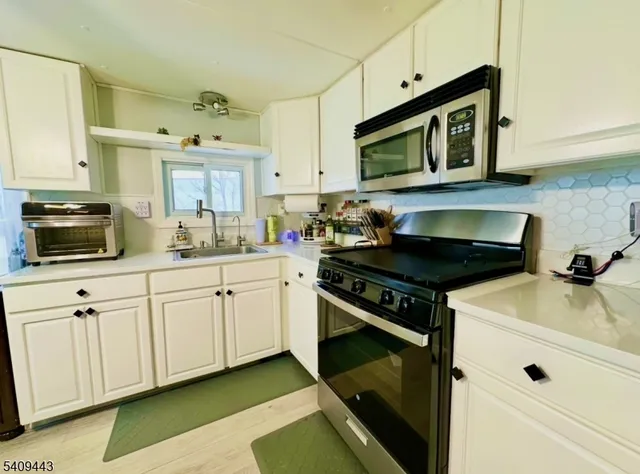 a kitchen with stainless steel appliances a stove a microwave sink and cabinets