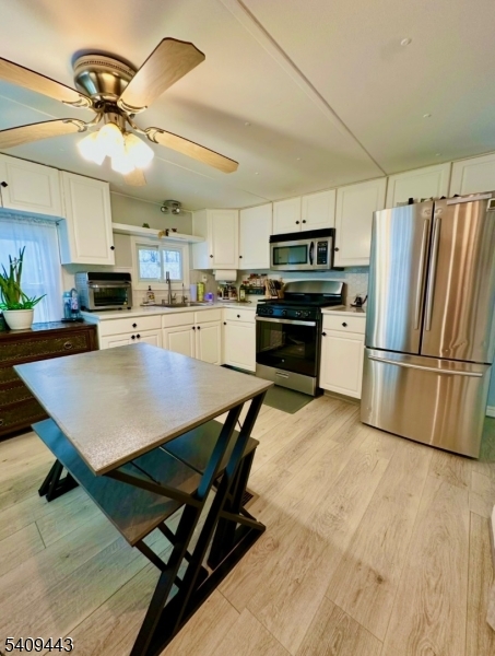 26 Dalbert Street Carteret, NJ 07008 - Photo 4 of 34 a kitchen with stainless steel appliances kitchen island granite countertop a table chairs refrigerator and microwave