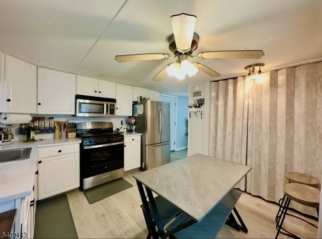 a kitchen with stainless steel appliances kitchen island a refrigerator sink and stove