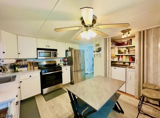 a kitchen with stainless steel appliances a stove refrigerator and cabinets
