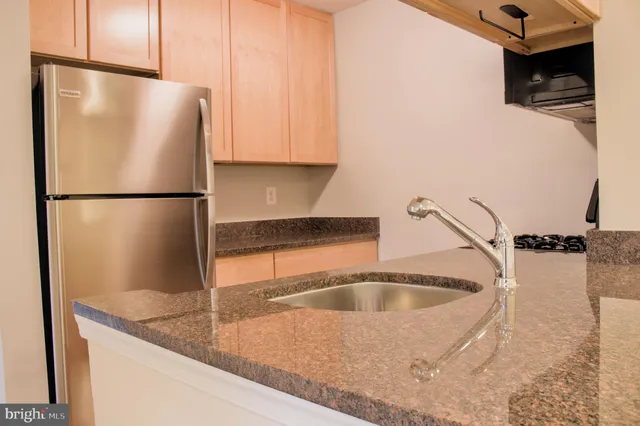 a kitchen with a refrigerator sink and cabinets
