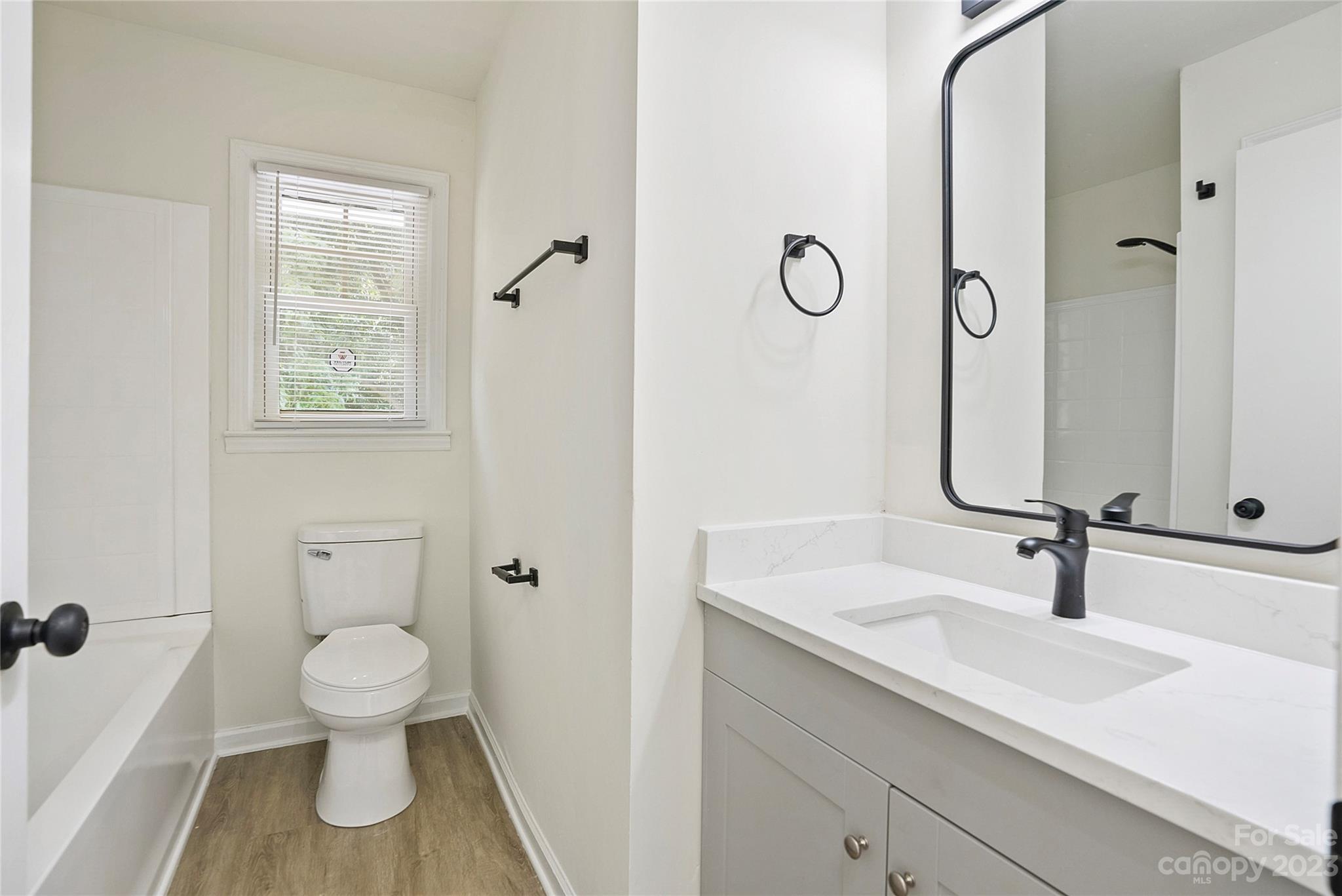 1424 Echo Glen Road Charlotte, NC 28213 - Photo 18 of 26 a bathroom with a toilet sink a mirror and shower