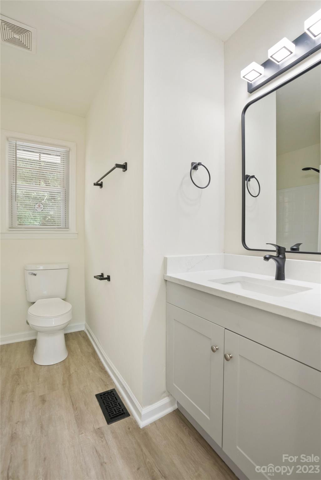 1424 Echo Glen Road Charlotte, NC 28213 - Photo 19 of 26 a bathroom with a toilet a sink and mirror