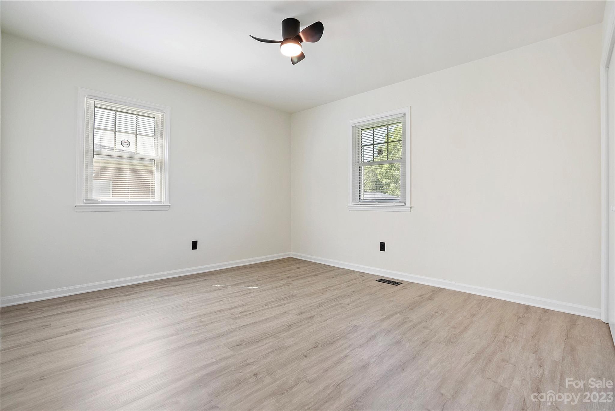 1424 Echo Glen Road Charlotte, NC 28213 - Photo 21 of 26 an empty room with wooden floor and windows