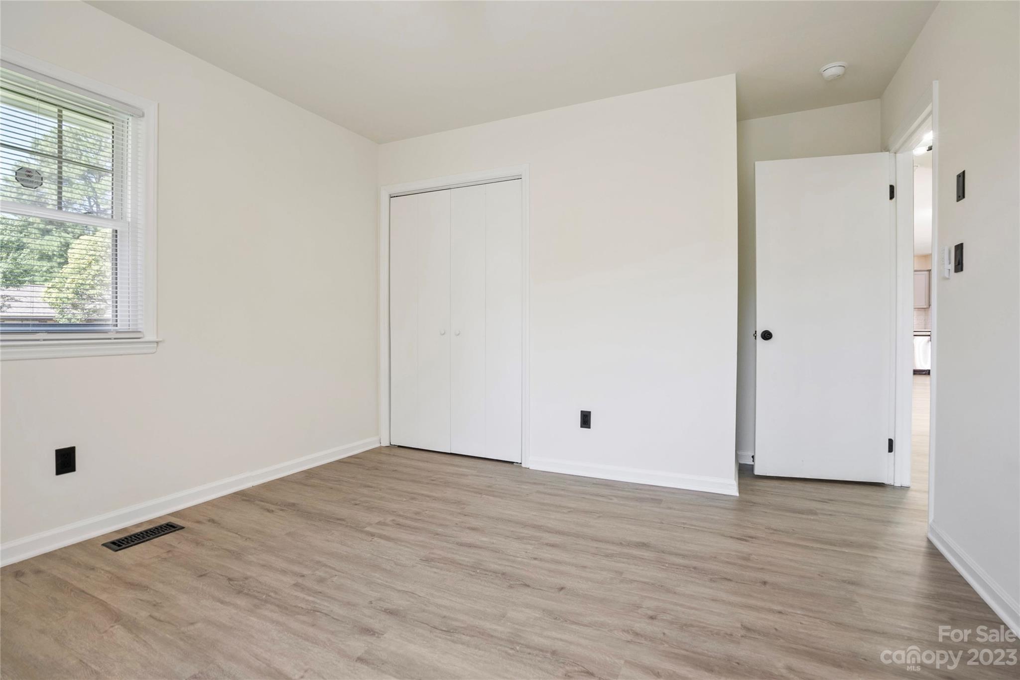 1424 Echo Glen Road Charlotte, NC 28213 - Photo 22 of 26 a view of an empty room with wooden floor and a window