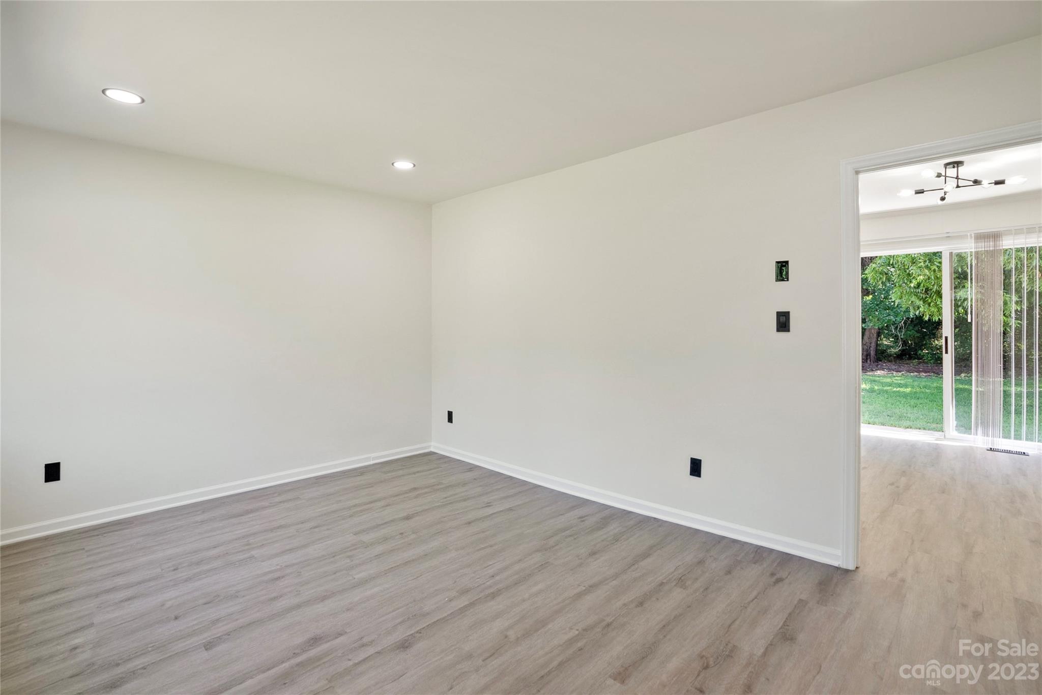 1424 Echo Glen Road Charlotte, NC 28213 - Photo 7 of 26 an empty room with wooden floor and windows