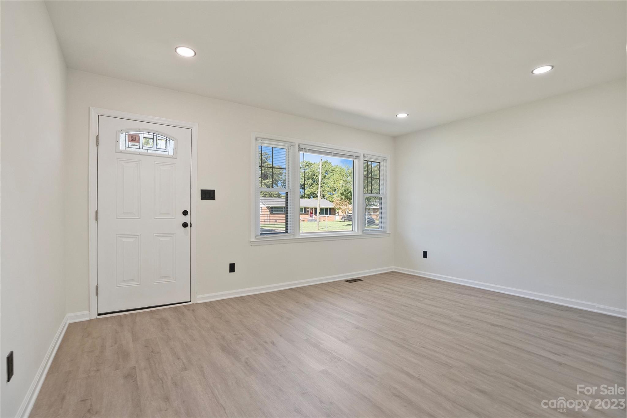 1424 Echo Glen Road Charlotte, NC 28213 - Photo 8 of 26 a view of an empty room with wooden floor and a window