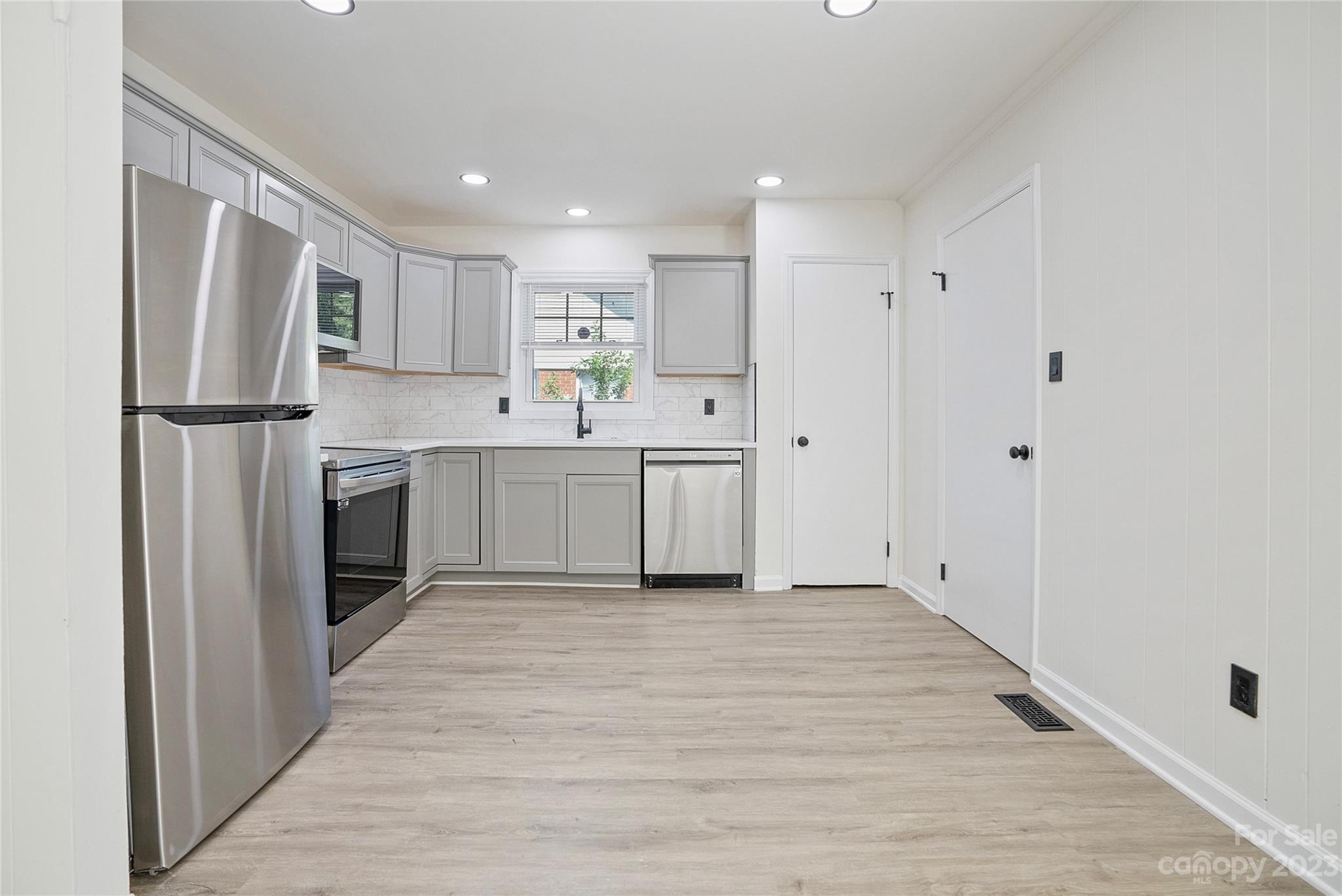 1424 Echo Glen Road Charlotte, NC 28213 - Photo 10 of 26 a kitchen with white cabinets and stainless steel appliances