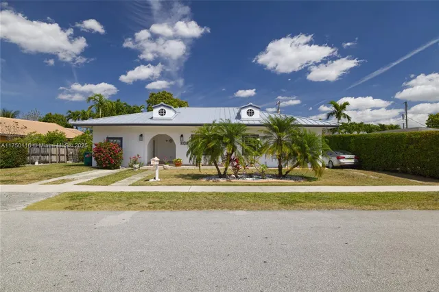 a view of a house with a big yard and a large trees