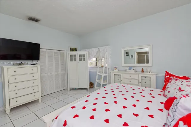 a white bath tub sitting in a bedroom next to a lamp and a dresser