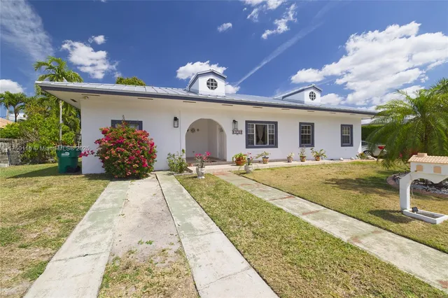 a front view of house with a garden