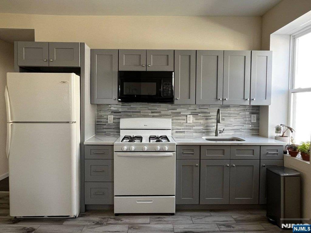 183 Bergen Turnpike Ridgefield Park, NJ 07660 - Photo 3 of 6 a kitchen with a sink a stove a refrigerator and cabinets