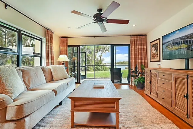 a living room with furniture large windows and flat screen tv