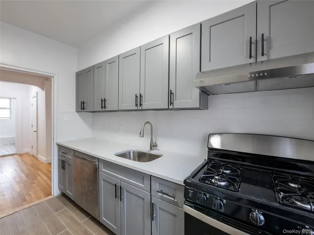 a kitchen with stainless steel appliances a sink dishwasher stove and cabinets