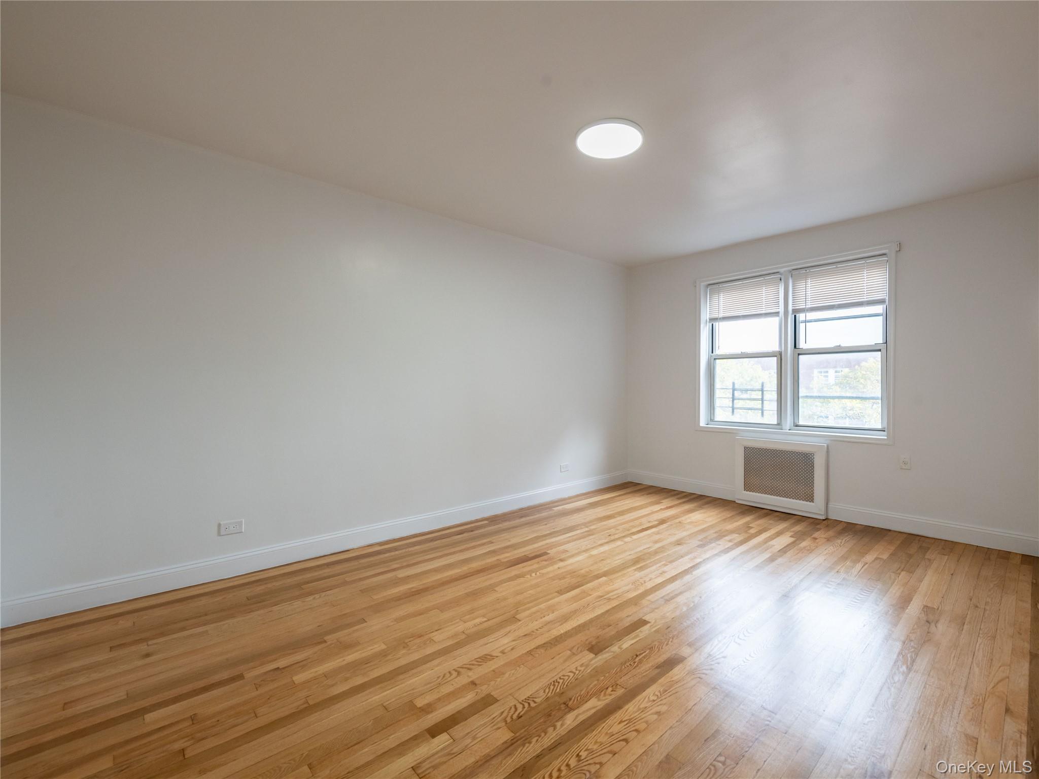 63-60 102nd Street, Unit D11 Queens, NY 11374 - Photo 14 of 21 a view of an empty room with wooden floor and a window