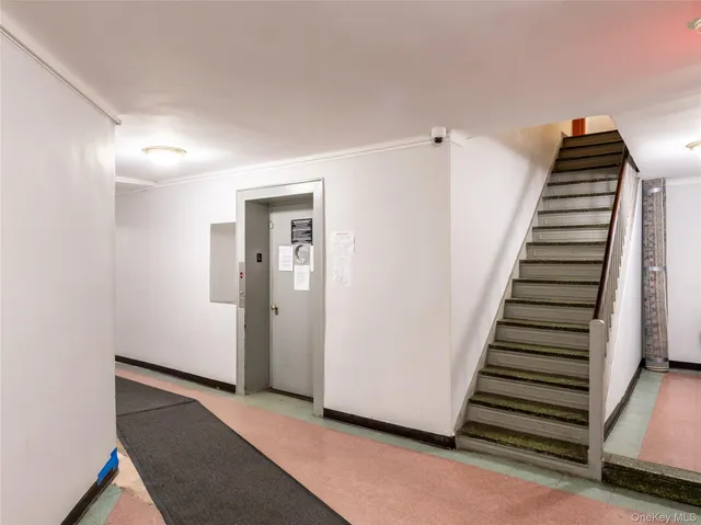 a view of a hallway with entryway and stairs