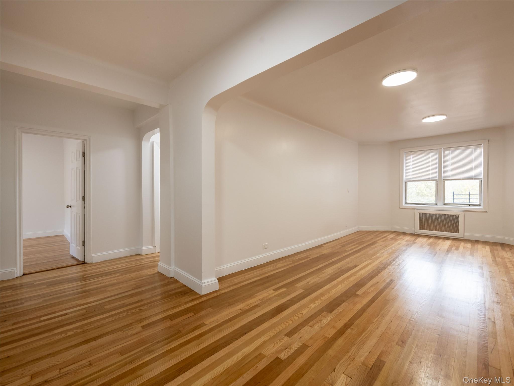 63-60 102nd Street, Unit D11 Queens, NY 11374 - Photo 6 of 21 an empty room with wooden floor and windows