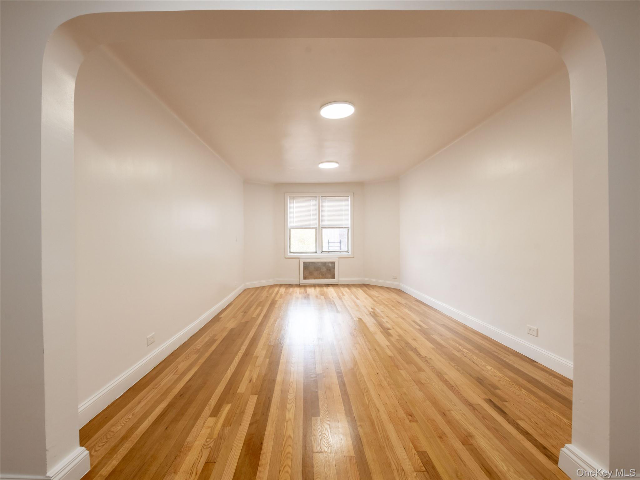 63-60 102nd Street, Unit D11 Queens, NY 11374 - Photo 8 of 21 an empty room with wooden floor and windows