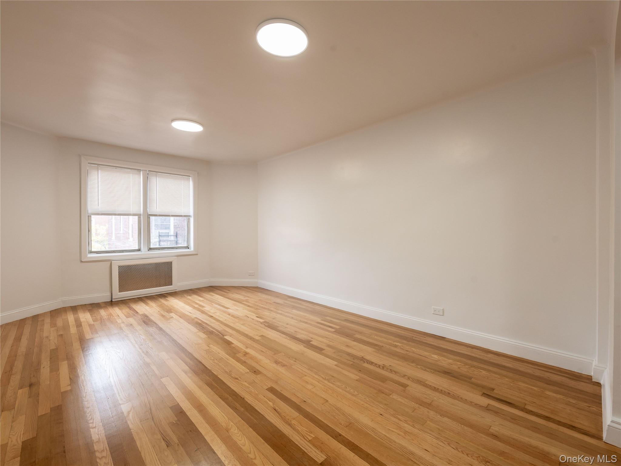 63-60 102nd Street, Unit D11 Queens, NY 11374 - Photo 10 of 21 an empty room with wooden floor and windows
