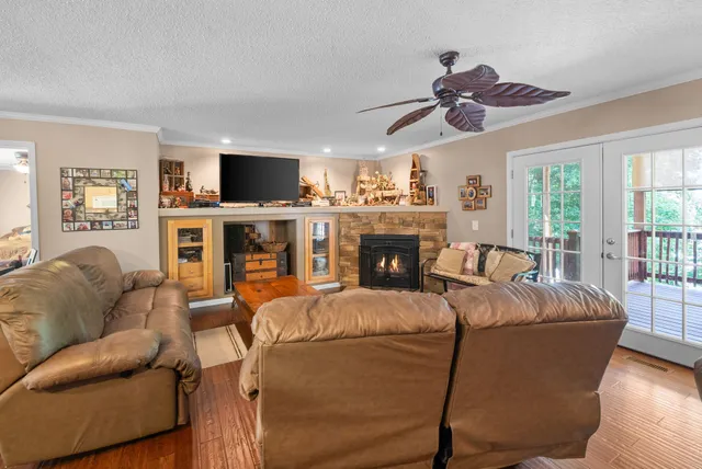 a living room with stainless steel appliances kitchen island granite countertop furniture and a wooden floor