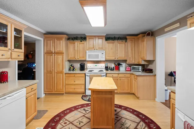 a living room with stainless steel appliances granite countertop furniture a couch a stove a kitchen island and large windows