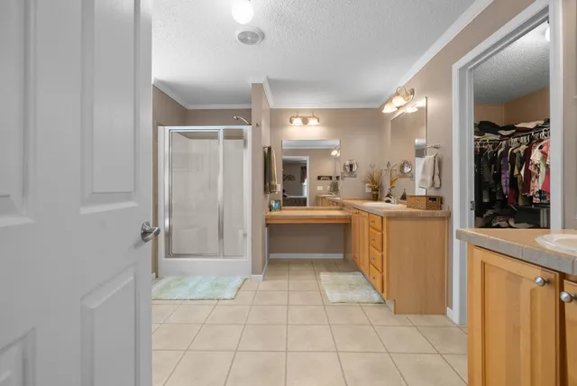 a bedroom with a bed a flat screen tv and a large window