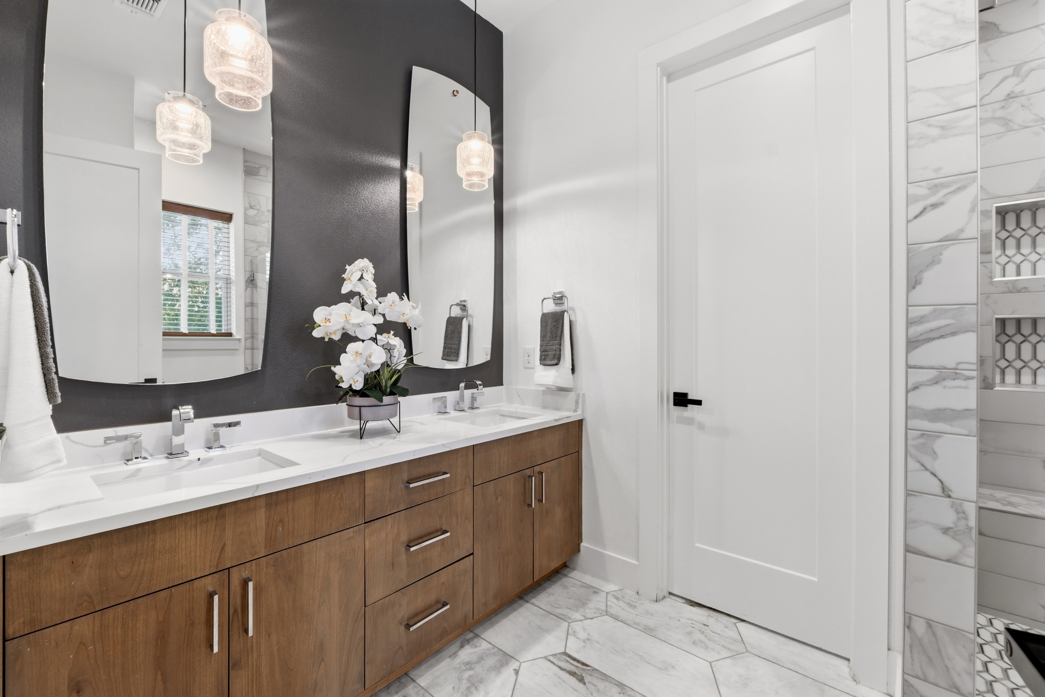 3304 East 17th Street, Unit B Austin, TX 78721 - Photo 19 of 35 A refined bathroom features dual vanities, modern lighting, and elegant hexagonal floor tiles. Private water closet area is beyond the door