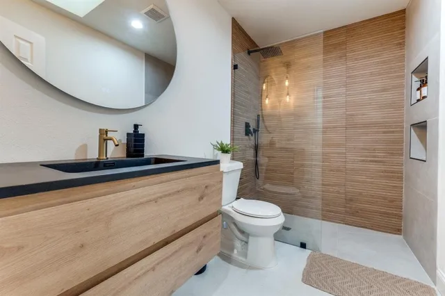 a bathroom with a sink a toilet and shower