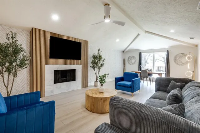 a living room with furniture a flat screen tv and a fireplace