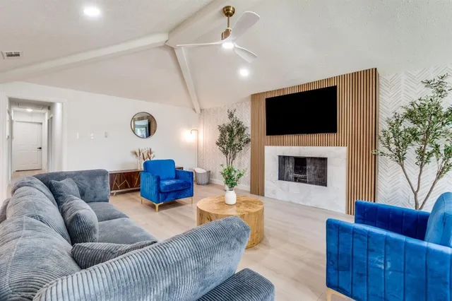 a living room with furniture a flat screen tv and a fireplace