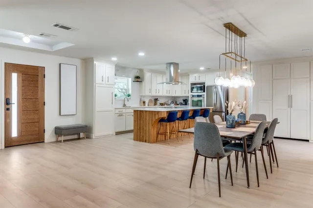 a dining area with furniture a chandelier and kitchen view