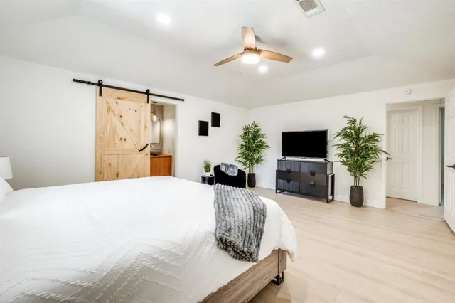 a bedroom with a bed potted plant and a flat screen tv
