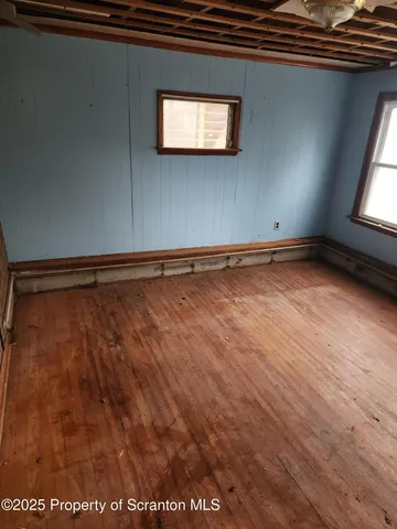 a view of a room with wooden floor and windows
