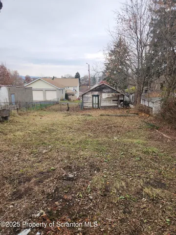 a view of residential houses with yard and mountain view in back